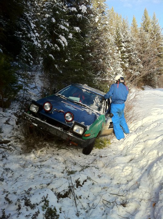 a toyota corolla rests perched on the side of a ditch after a bit of an off