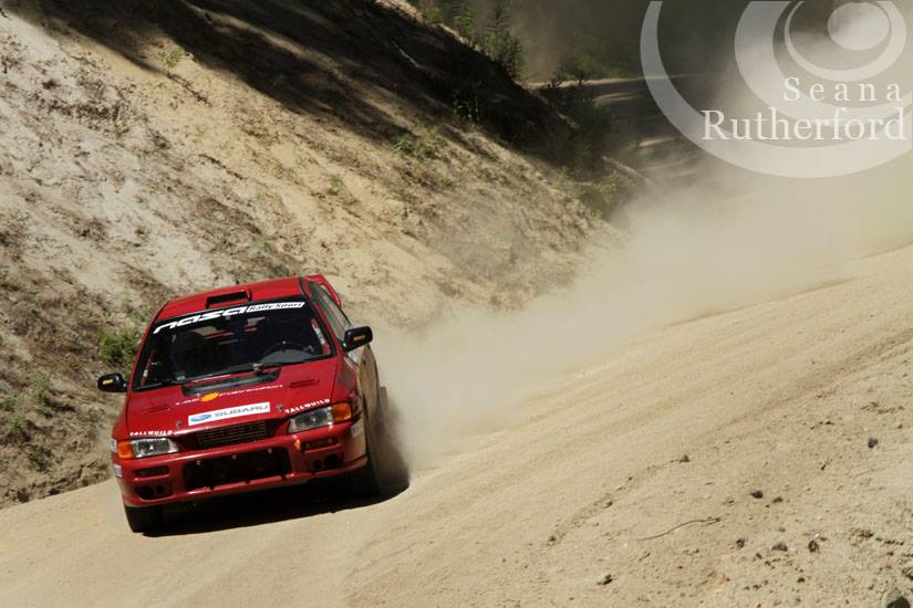 image of a red subaru drifing on a gravel road