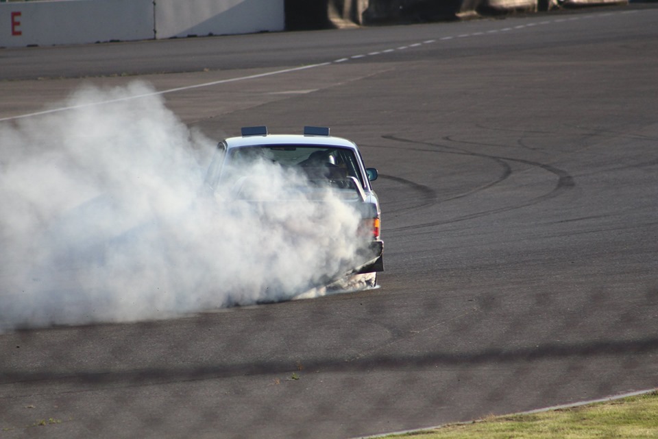 a powerful rally volvo annihilating tires in a massive drift on a racetrack