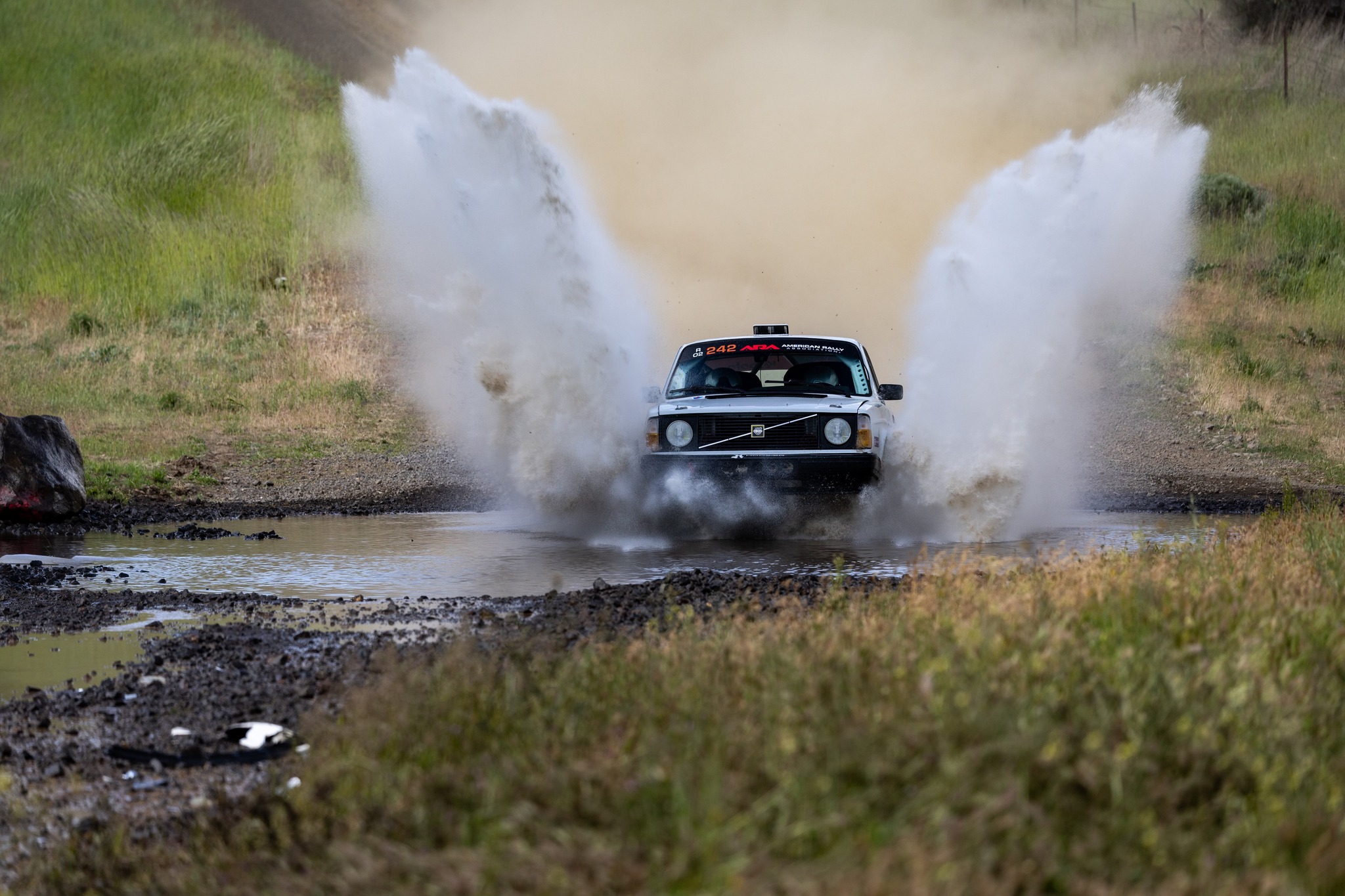 a fancy Volvo kicks up a huge watersplash without taking any damage whatsoever